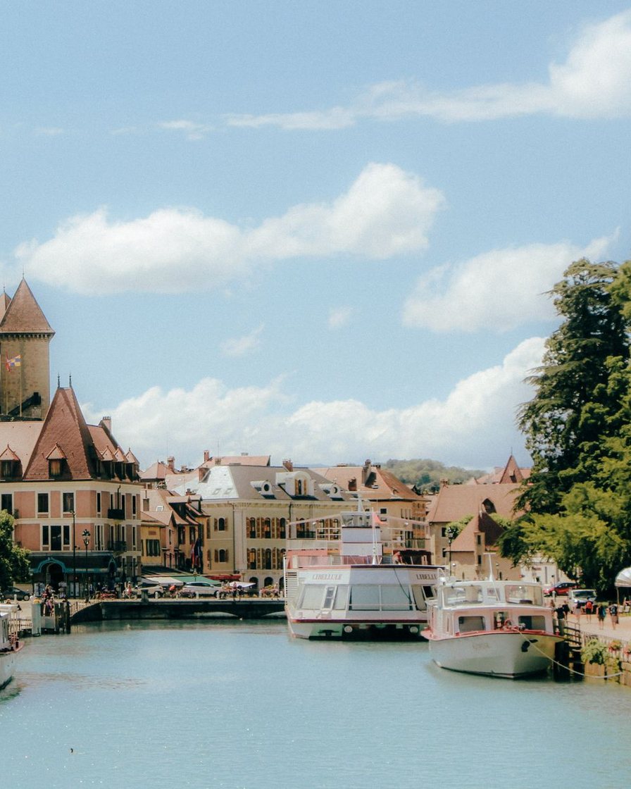 Château de Duingt sur sa presqu'île qui sépare le Grand Lac du Petit Lac d'Annecy, eau turquoise et montagnes en arrière-plan