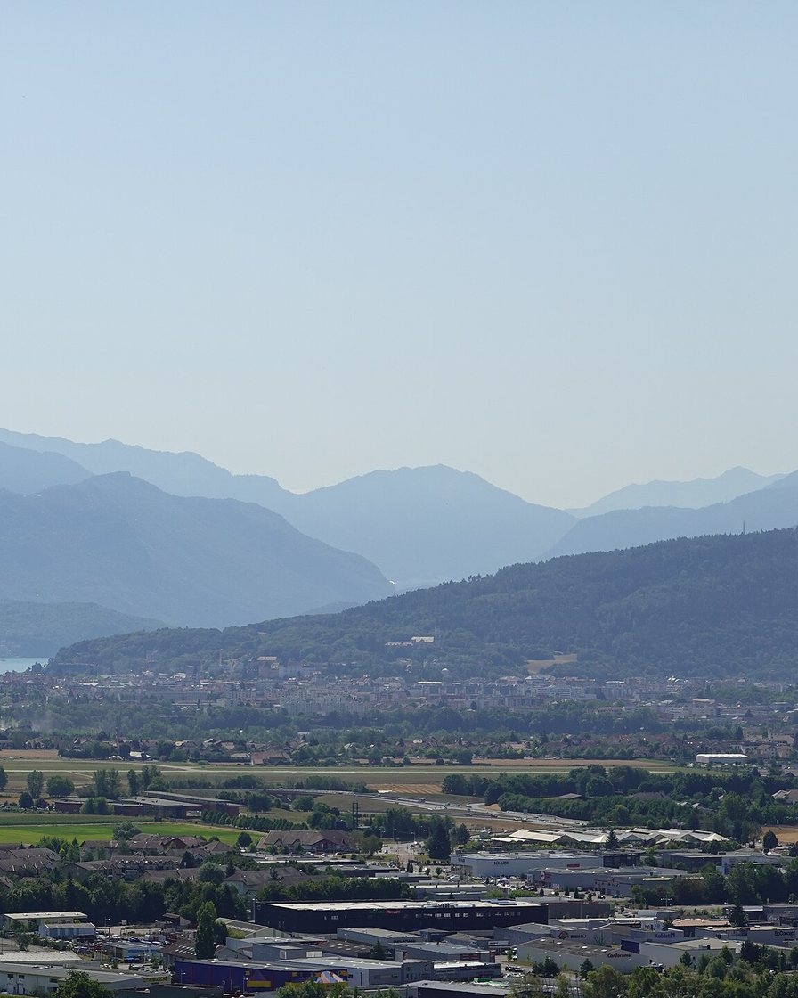 Pointe nord du lac d'Annecy avec la ville au bord de l'eau et les sommets des Préalpes au sud