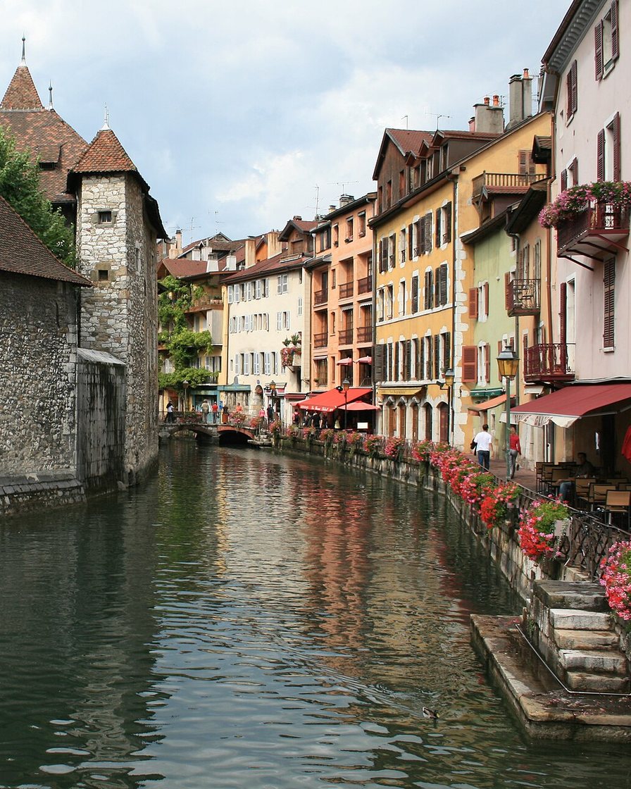 Rues piétonnes à arcades et canaux du Thiou dans la vieille ville d'Annecy, façades colorées et pont de pierre